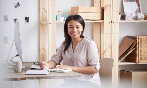 smiling-mixed-race-woman-at-desk-PY2ZLH6.jpg